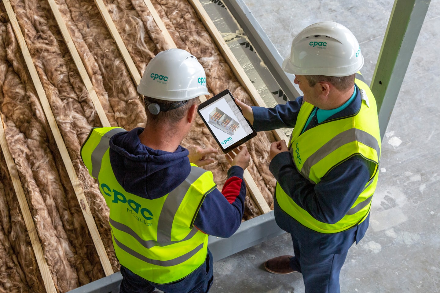 Unos obreros de la construcción revisan planos en una tableta.